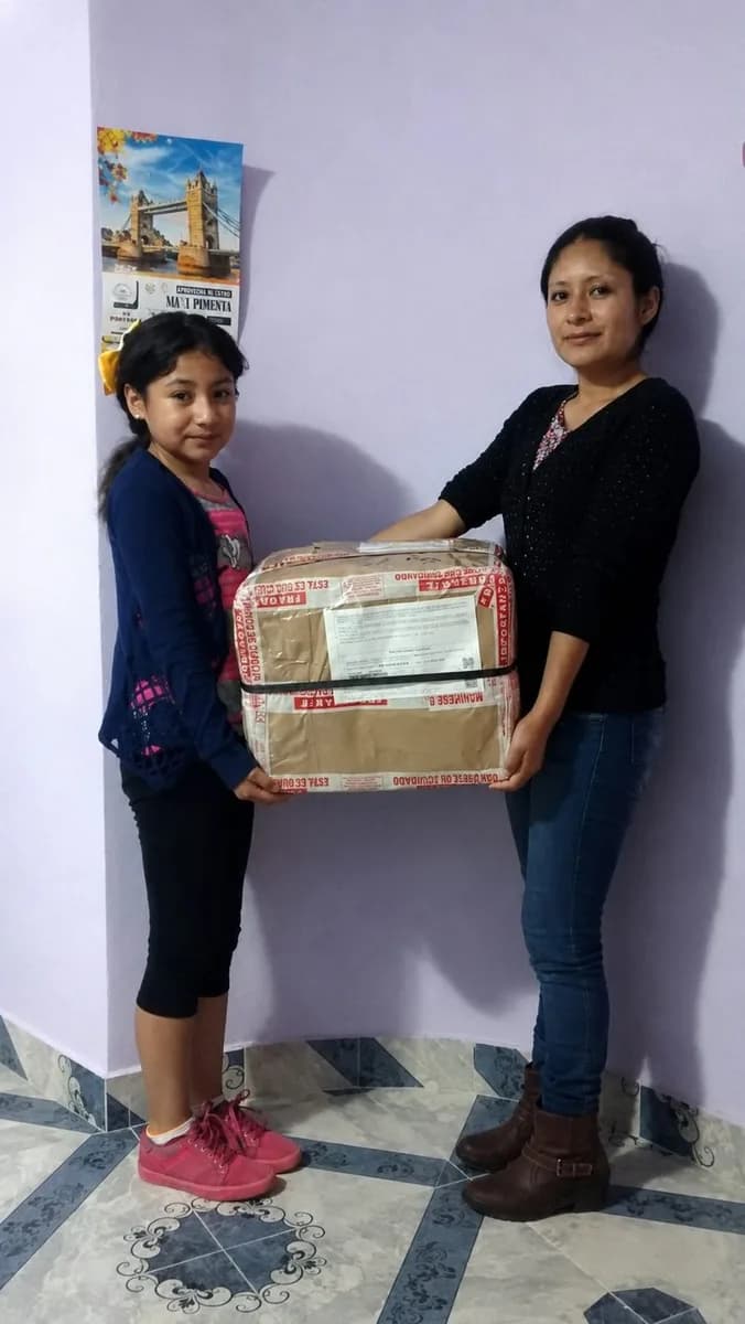 Familia recibiendo su caja de Paquetería Colibrí
